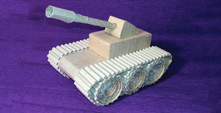 an origami model of a tank on purple fabric with the top folded down