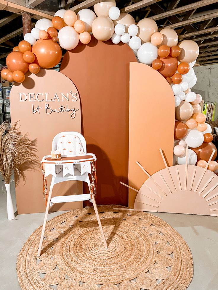 a chair sitting on top of a rug in front of a wall covered with balloons