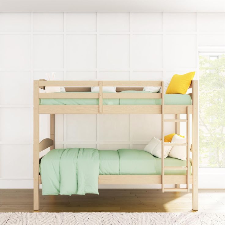 a wooden bunk bed with green sheets and pillows on the bottom level, against a white wall