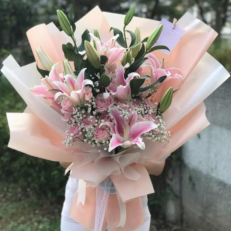 a woman holding a bouquet of pink flowers