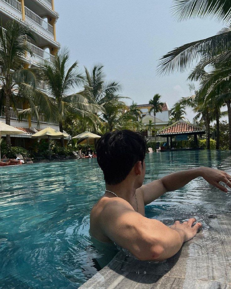 a man is sitting in the middle of a swimming pool and taking a photo with his cell phone