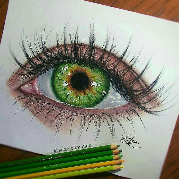 a drawing of an eye with colored pencils next to it