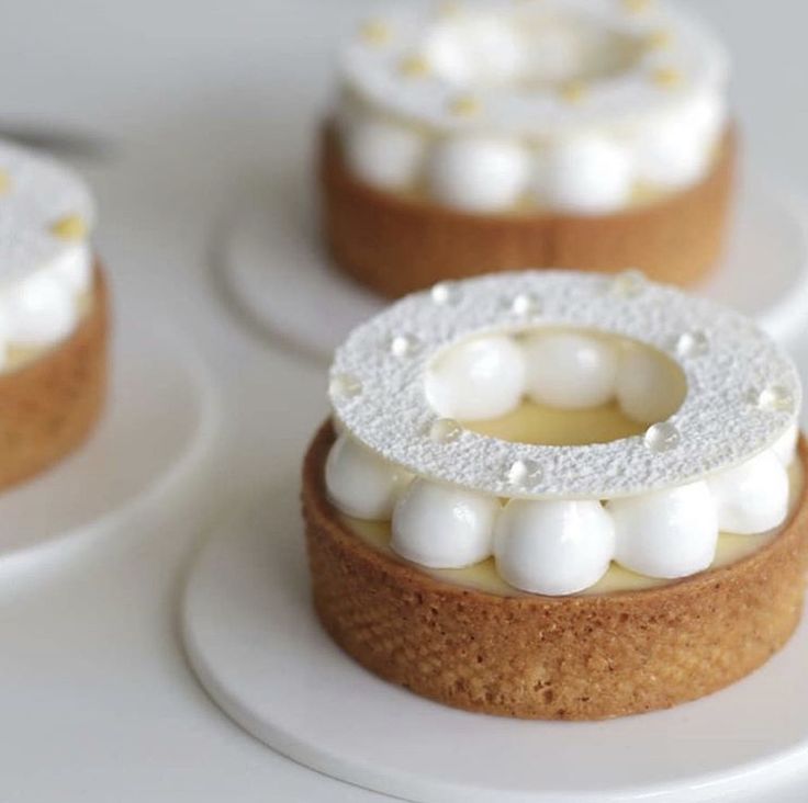 three small cakes with white frosting on them