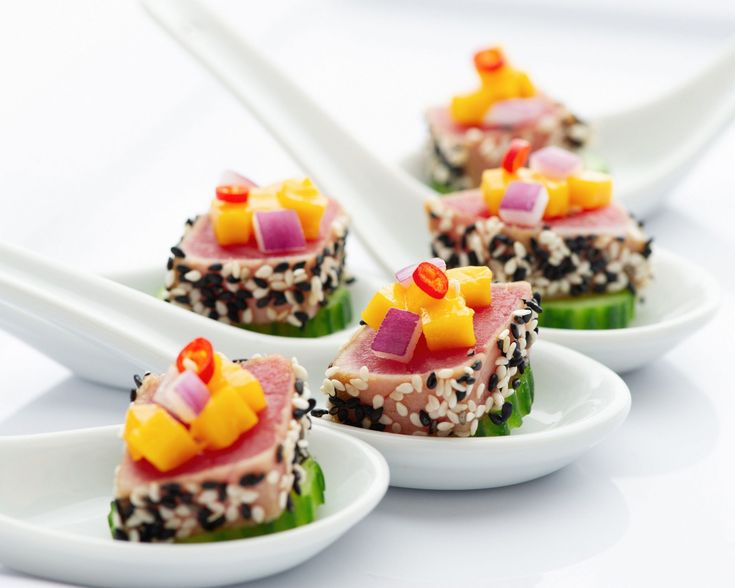 four small white plates topped with food and chopsticks on top of each other