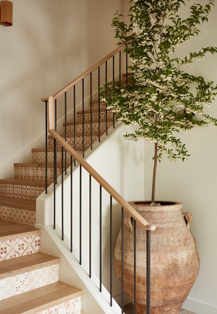 a potted plant sitting on top of a stair case next to a banister