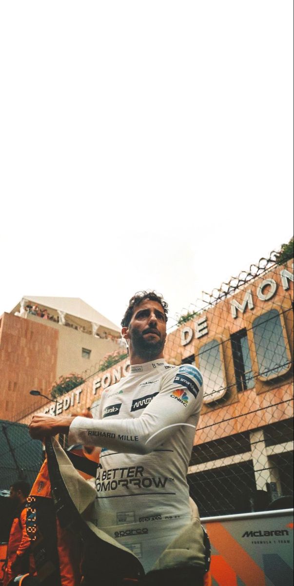 a man riding on the back of a motorcycle in front of a tall brown building