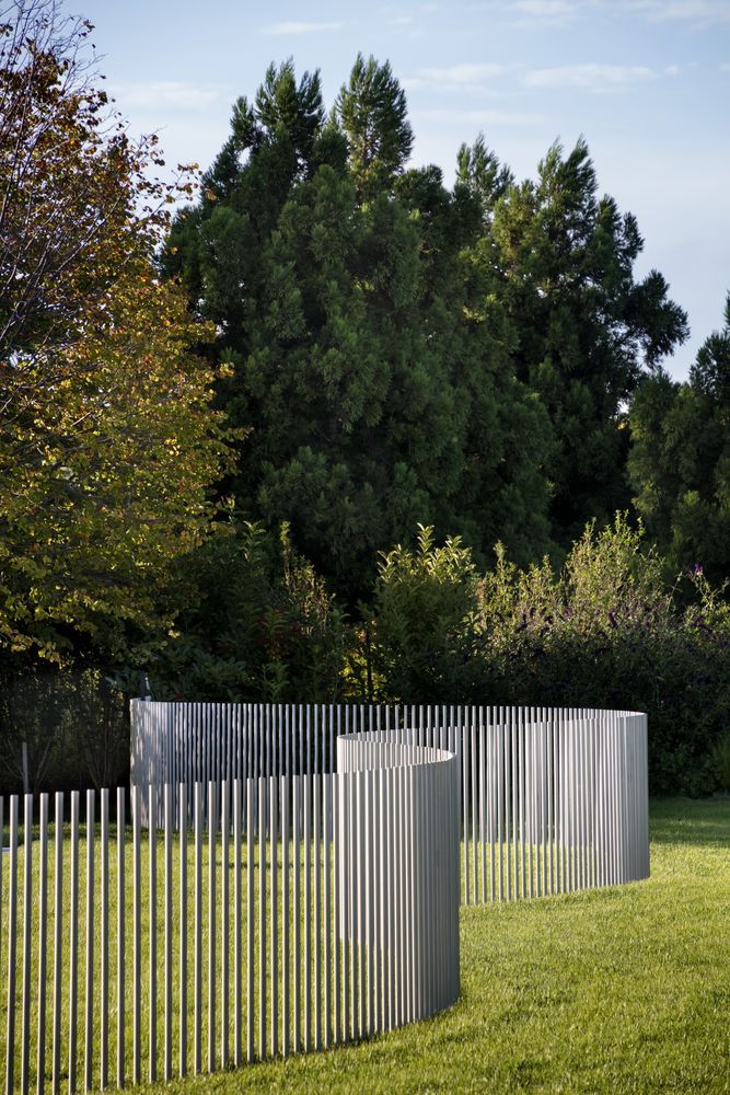 two metal fences in the middle of a grassy field