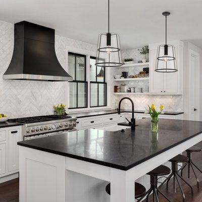 a kitchen with white cabinets and black counter tops