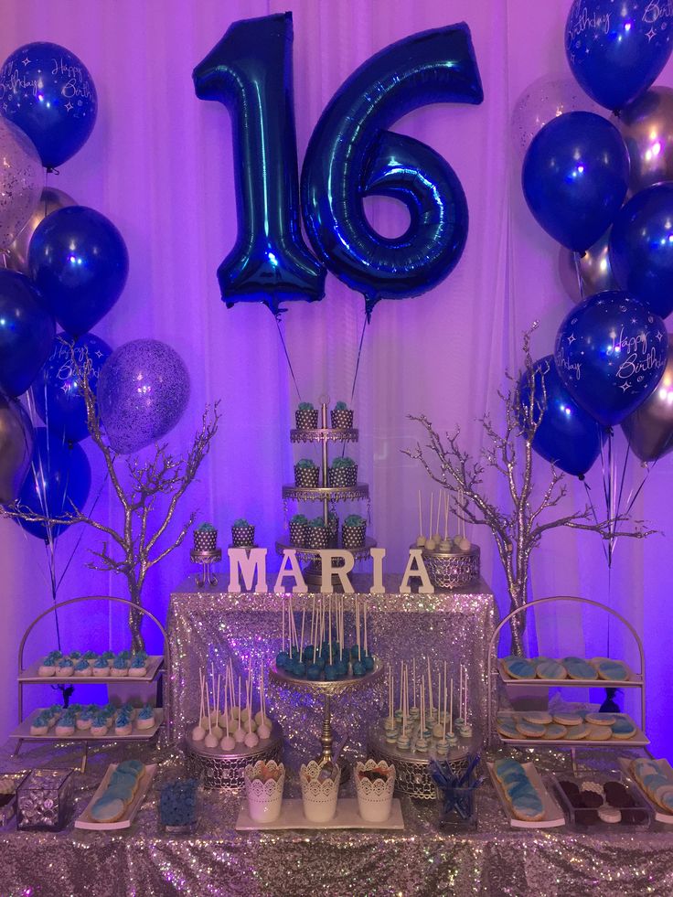 a table topped with cake and balloons next to a number 16 sign on the wall