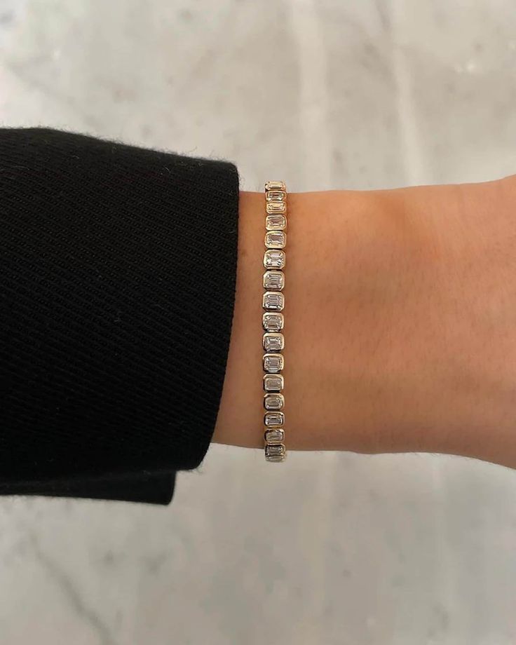 Bezel Set Emerald Cut Diamond Tennis Bracelet: Luxuriate in 5 carats of sparkling lab-grown diamonds, exquisitely set in 14K gold. This custom bracelet radiates elegance and is a perfect Valentine's Day gift. 𝐅𝐞𝐚𝐭𝐮𝐫𝐞𝐬: * 𝐌𝐚𝐝𝐞 𝐭𝐨 𝐎𝐫𝐝𝐞𝐫 * 𝐌𝐞𝐭𝐚𝐥: 𝟏𝟒𝐊 * 𝐁𝐚𝐧𝐝 𝐂𝐨𝐥𝐨𝐫𝐬: Rose Gold, Yellow Gold & White Gold 𝐒𝐭𝐨𝐧𝐞: * 𝐒𝐭𝐨𝐧𝐞 - Lab Grown Diamond * 𝐒𝐡𝐚𝐩𝐞 - Emerald Cut * 𝐂𝐚𝐫𝐚𝐭 𝐖𝐞𝐢𝐠𝐡𝐭 - 5.25 Carats (Varies with Bracelet Size) * 𝐂𝐨𝐥𝐨𝐫 - F+ * 𝐂𝐥 Luxury Emerald Cut Bracelet With Prong Setting, Luxury Bezel-set Bracelet, Diamond Tennis Bracelet With 17 Jewels And Baguette Cut, Diamond Baguette Cut Tennis Bracelet, Luxury Gold Diamond Bracelet With Emerald Cut, Diamond Tennis Bracelet With Baguette Cut, Emerald Tennis Bracelet, Valentines Gift For Her, 2024 Wishlist