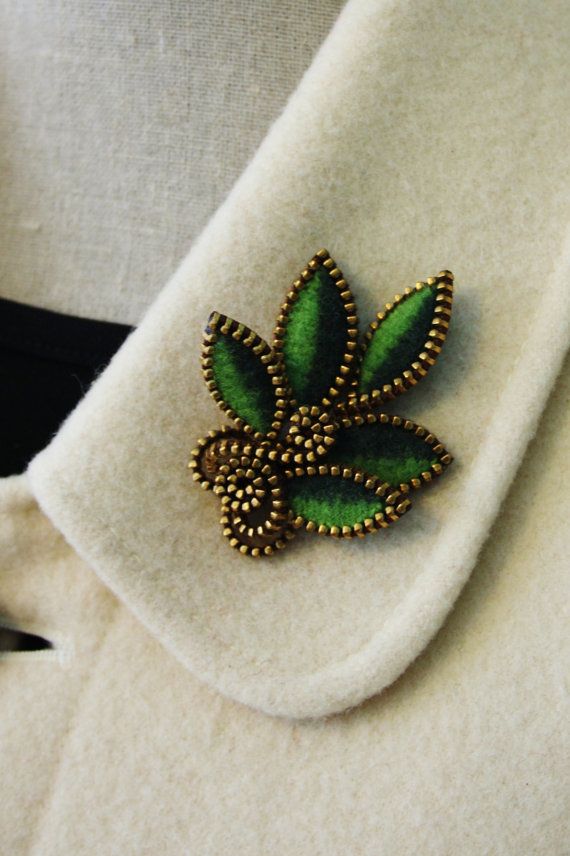 a green brooch sitting on top of a white napkin