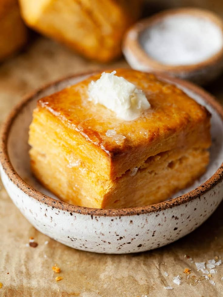 two pieces of cake in a bowl with some sugar on the top and one slice missing