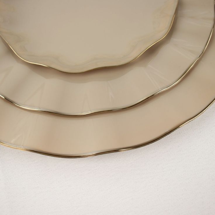 three plates sitting on top of each other with gold trimming around the edges and sides