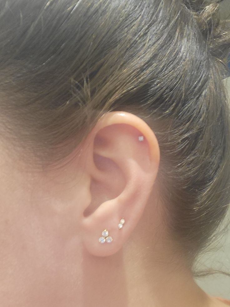 a close up of a person's ear with two piercings on it,