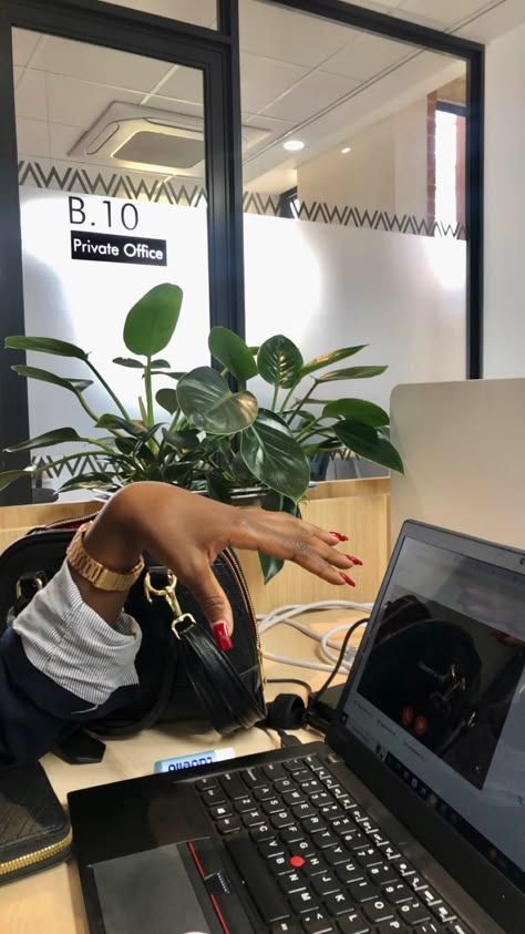 a woman sitting in front of a laptop computer with her hand on the keyboard,