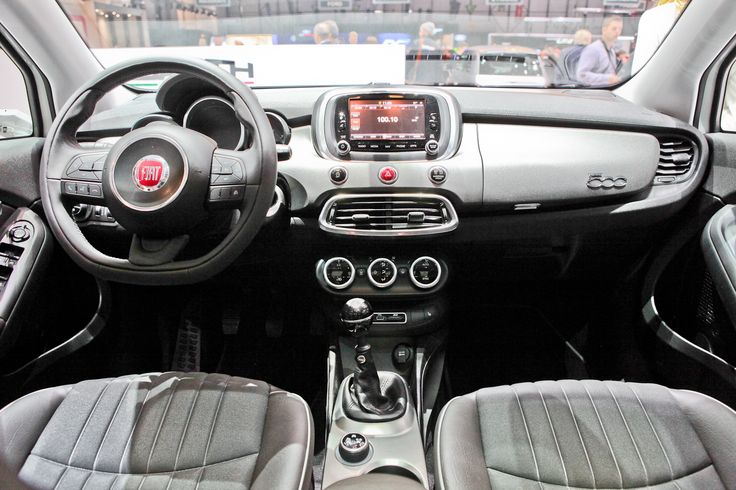 the interior of a small car with grey leather seats and dashboard controls on display at an auto show