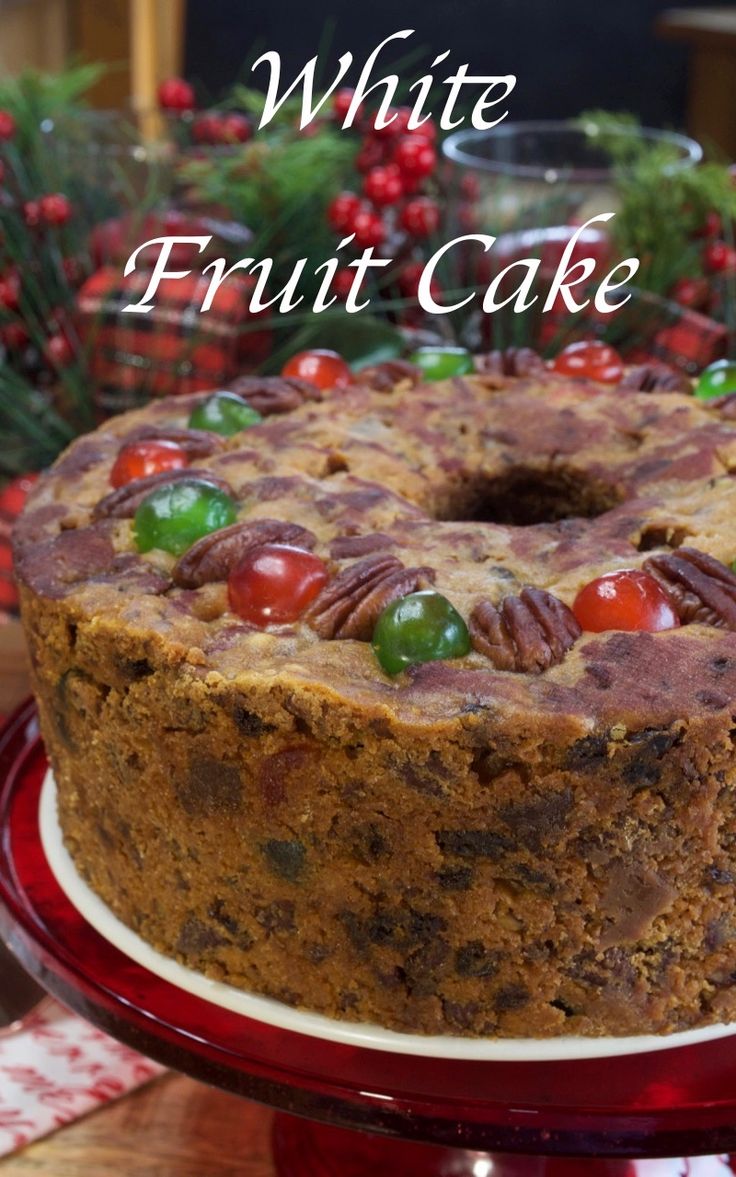 a cake on a red plate with white frosting and fruit in the top layer