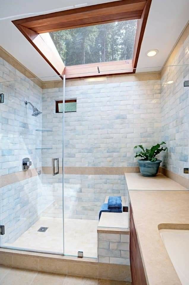 a bathroom with a skylight above it and a shower area next to the sink