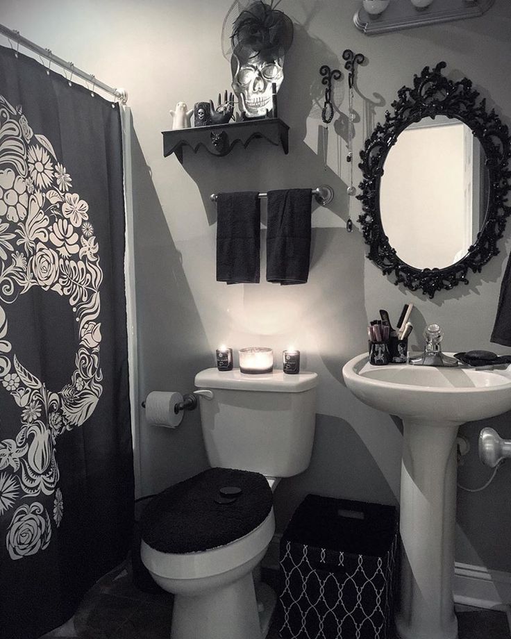 a white toilet sitting next to a sink in a bathroom under a black and white shower curtain