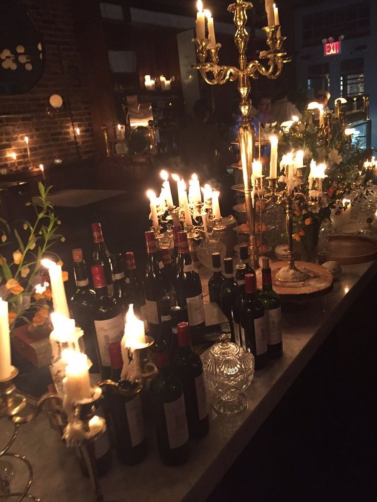 many bottles of wine and candles on a table