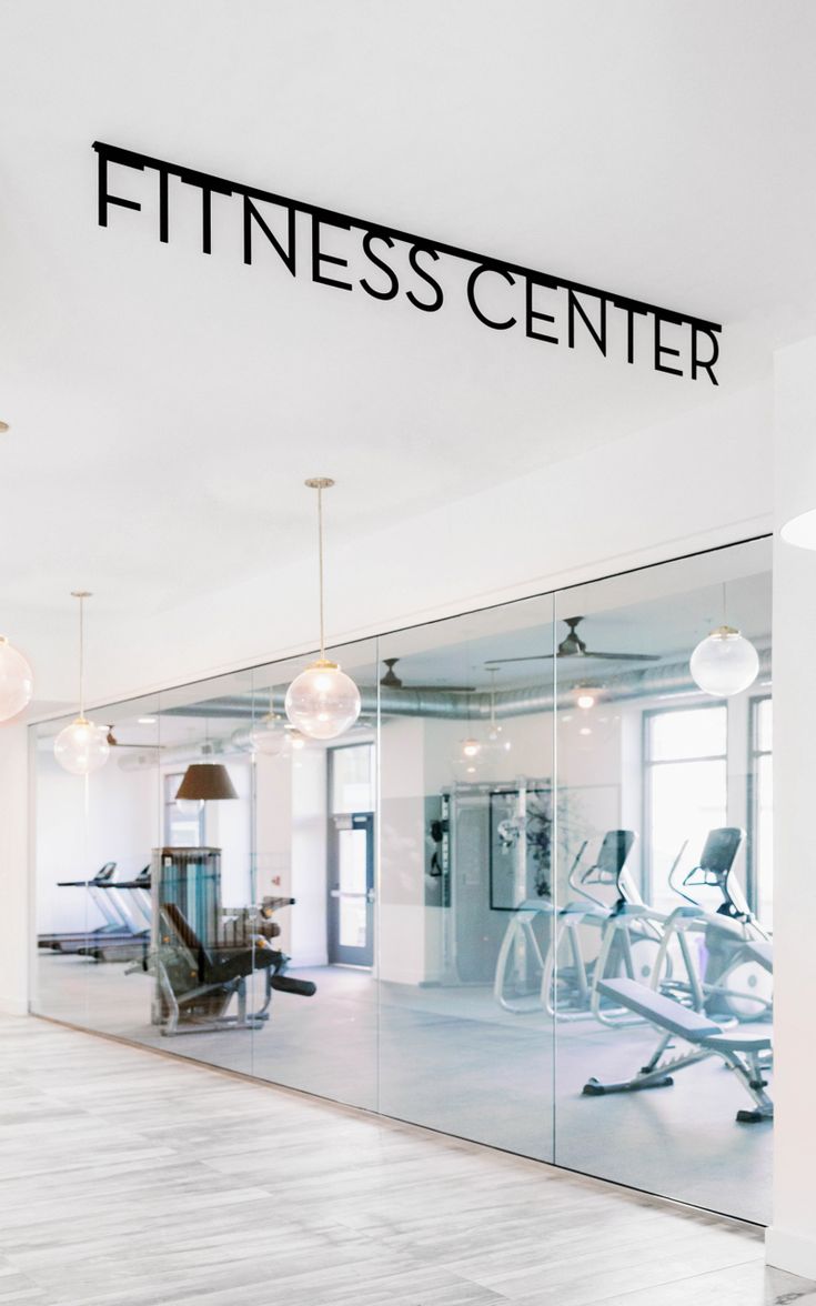 a gym with mirrors and exercise equipment in the background that says fitness center on it