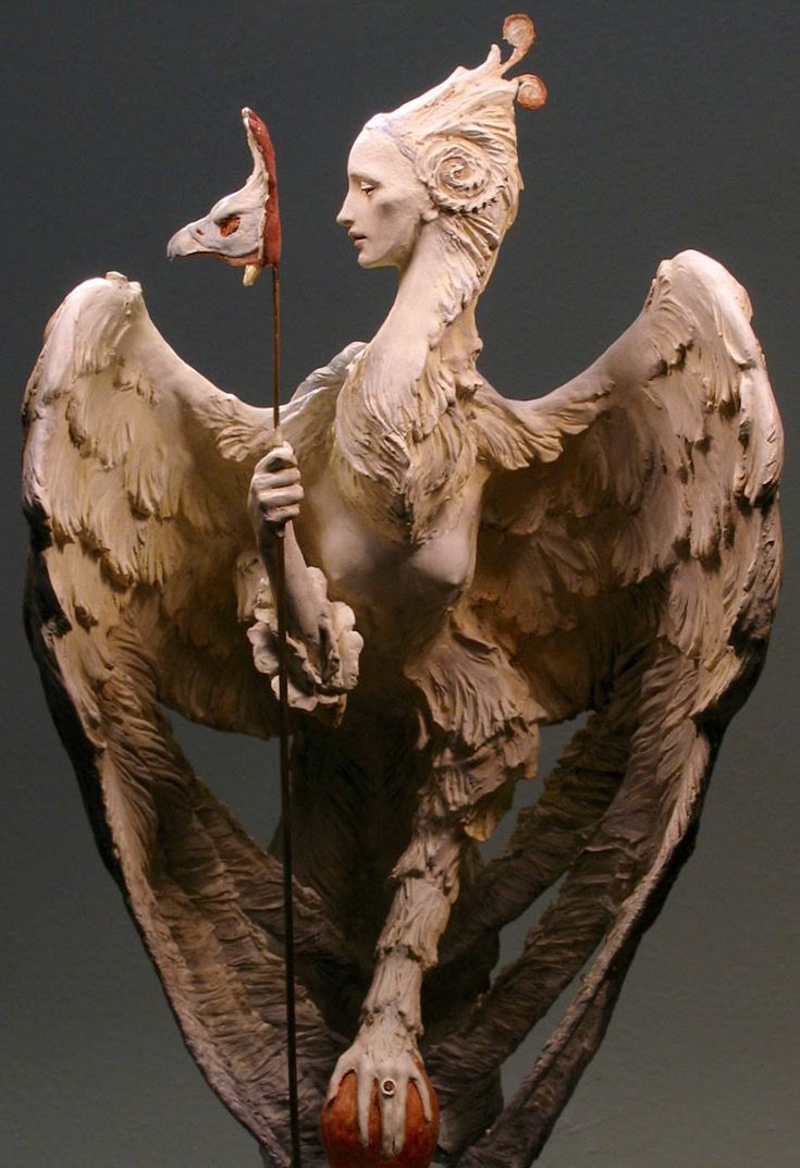 a statue of a woman holding a flag with an eagle on it's back