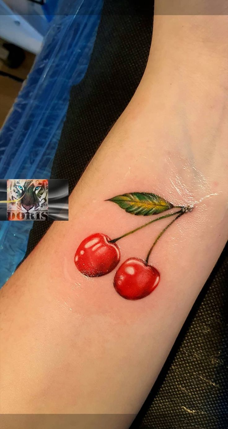 a small cherry tattoo on the arm