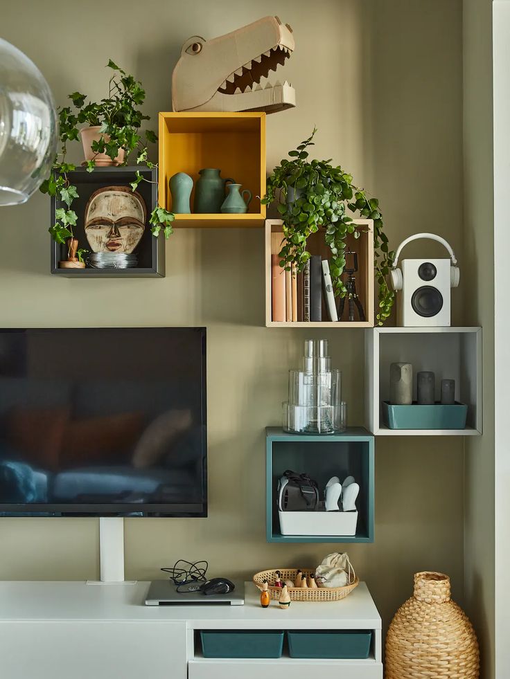 a flat screen tv sitting on top of a white entertainment center next to a vase