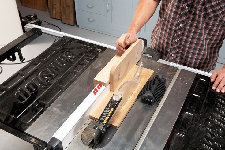 a man is using a table saw to cut wood