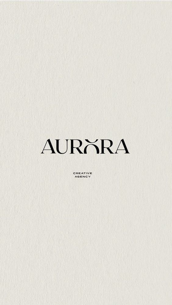 the word aurora is written in black ink on a white paper with an elegant font