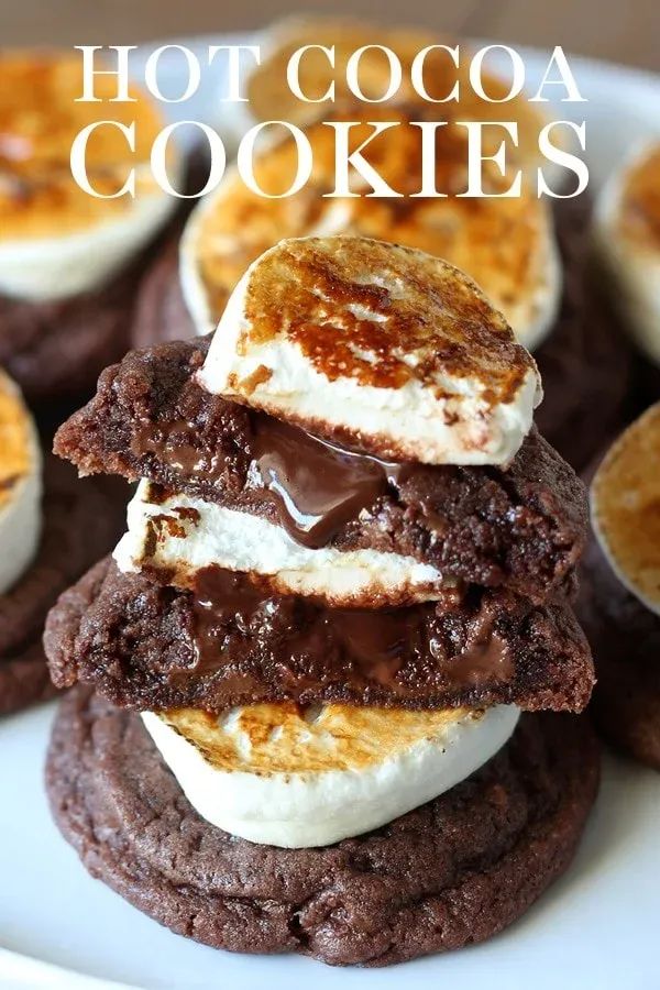 hot cocoa cookies with marshmallows and chocolate frosting are stacked on top of each other