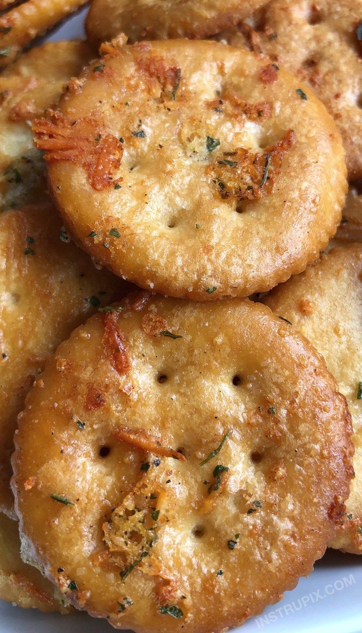 some fried food on a white plate with parmesan and seasoning sprinkles