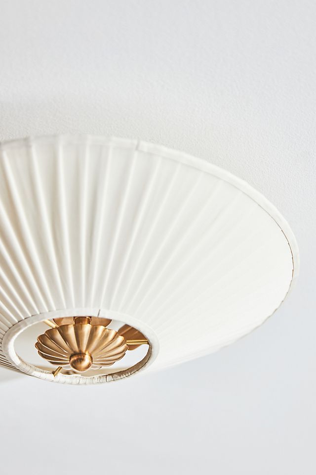 a close up of a white ceiling light with gold trim and fan blades on it