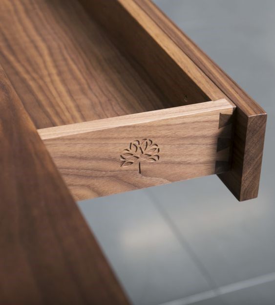 a close up of a wooden table with a drawer on it's side,