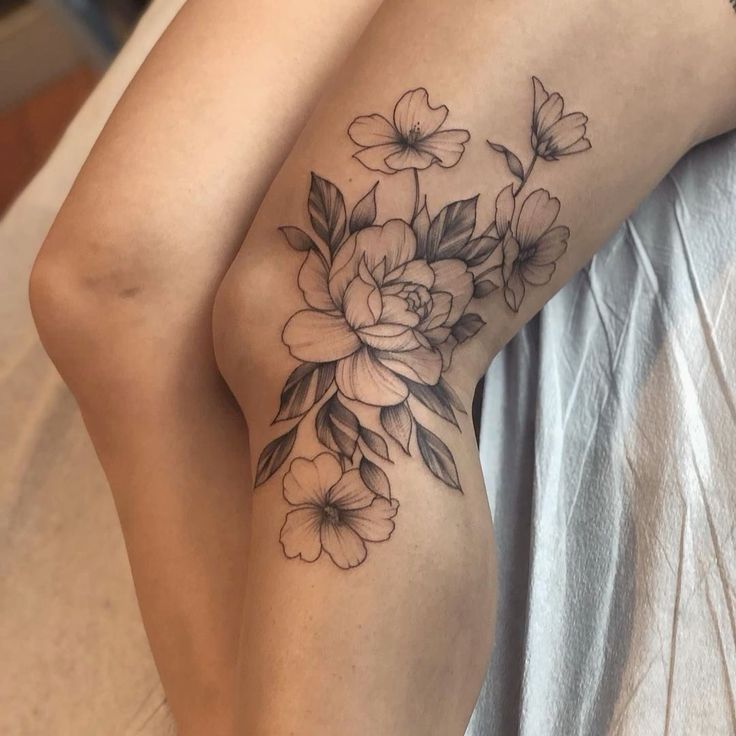 a woman's leg with flowers on it and the bottom half of her thigh