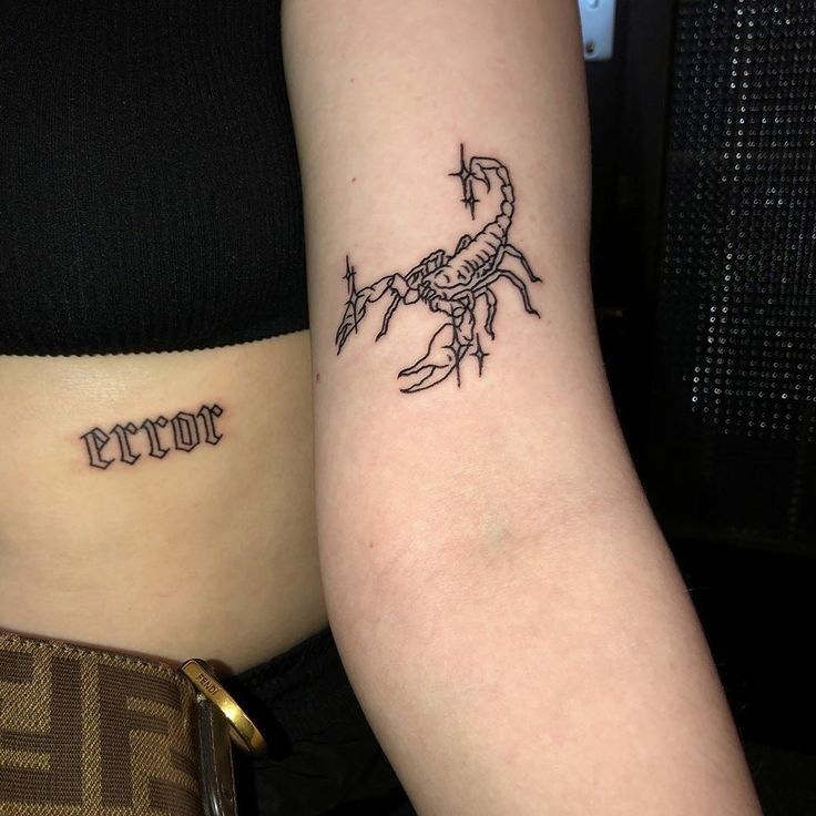 two people with tattoos on their arms, one has a scorpion and the other has a cross