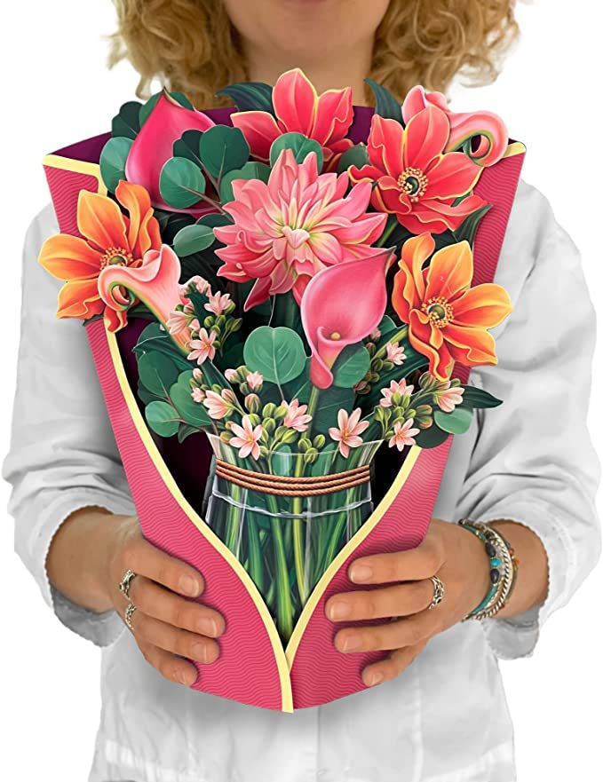 the woman is holding a bouquet of flowers in her hands and wearing a white shirt