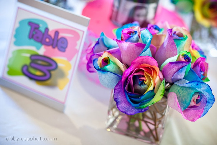 a vase filled with colorful roses on top of a table next to a greeting card