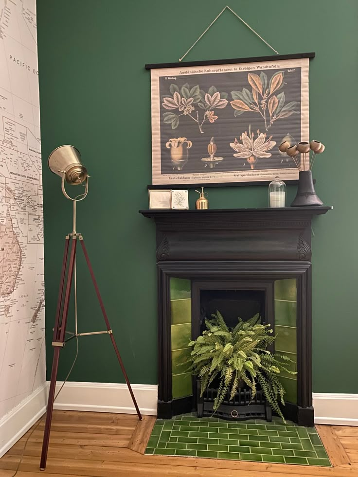 a living room with green walls and a map hanging on the wall above a fireplace