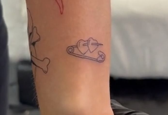 a person with a tattoo on their arm has a dog bone and heart in it