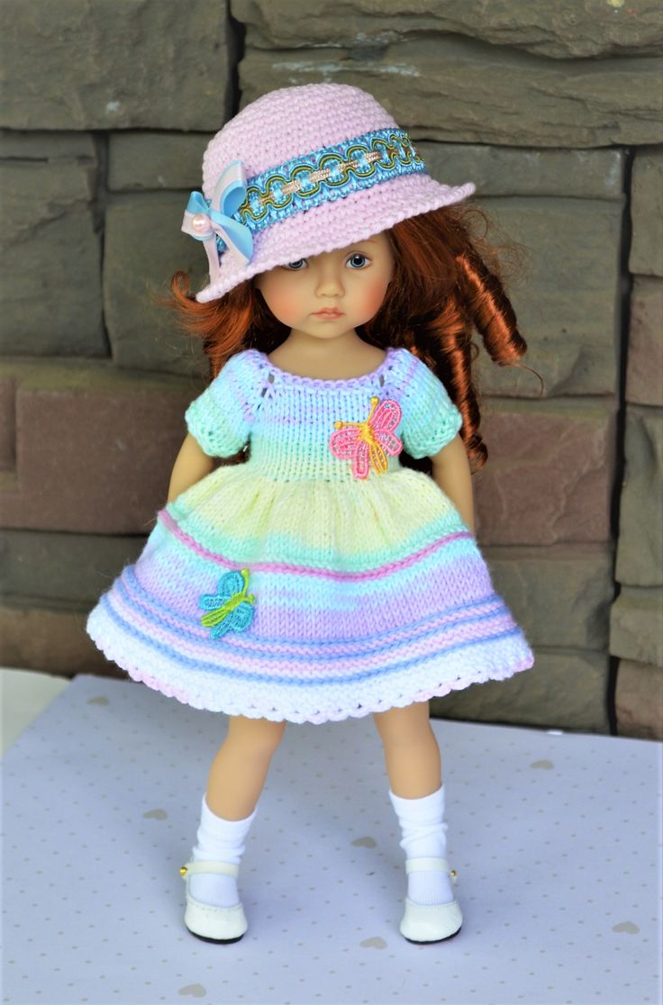 a doll is wearing a dress and hat