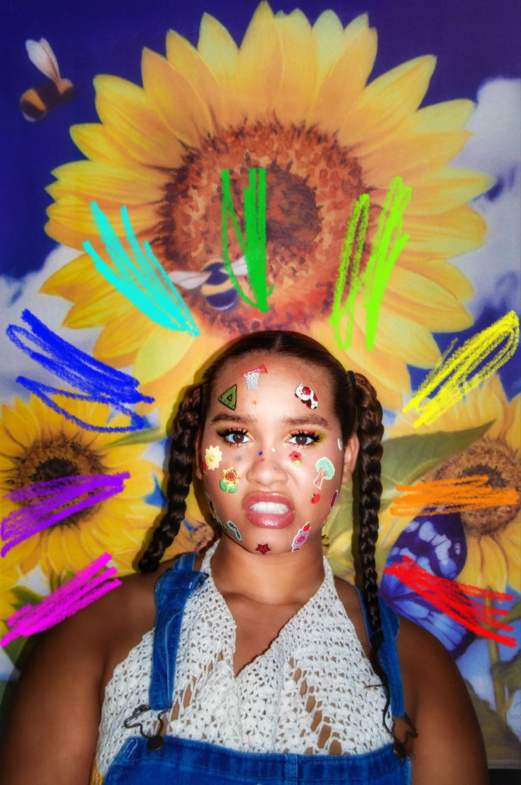 a girl with face paint and sunflowers on her head in front of a painting