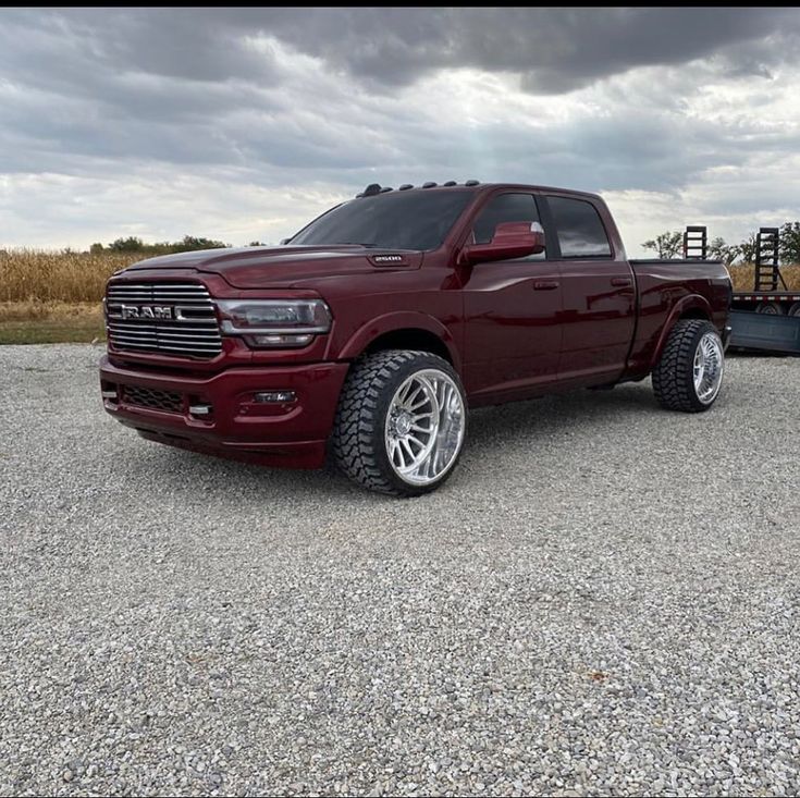 a red ram truck parked in a gravel lot