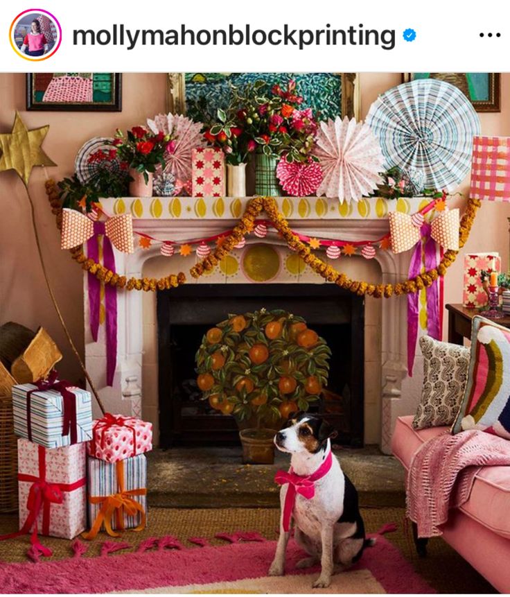 a dog is sitting in front of a fireplace decorated with pink, yellow and red decorations