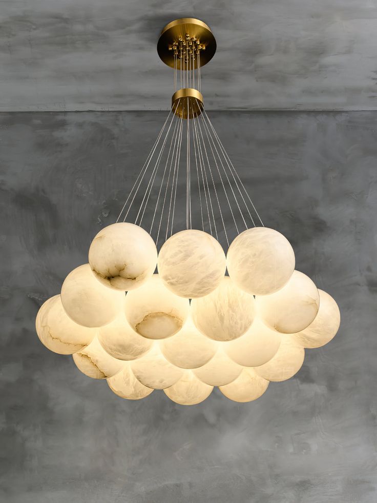 a modern chandelier with white balls hanging from the ceiling