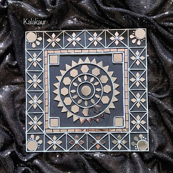 an intricately designed black and white tile with geometric designs on it's surface