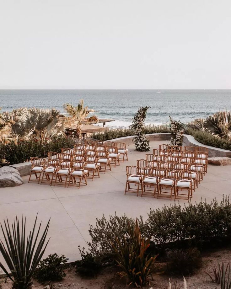 rows of chairs are set up in front of the ocean