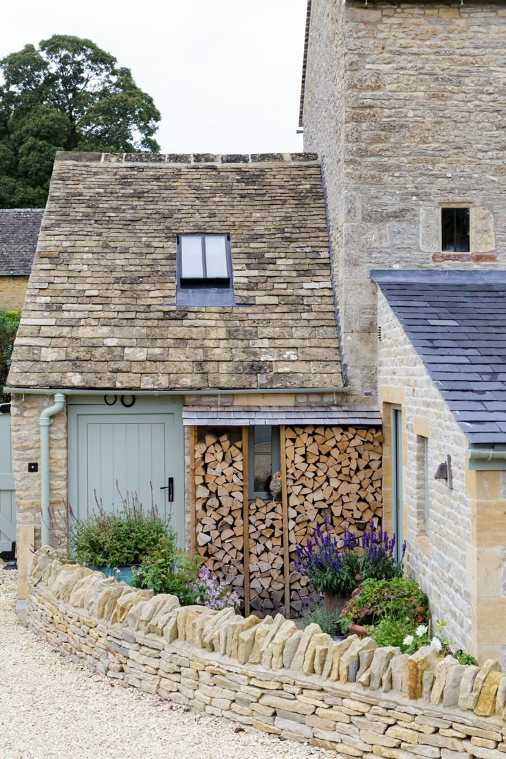 a stone building with lots of wood stacked on top of it