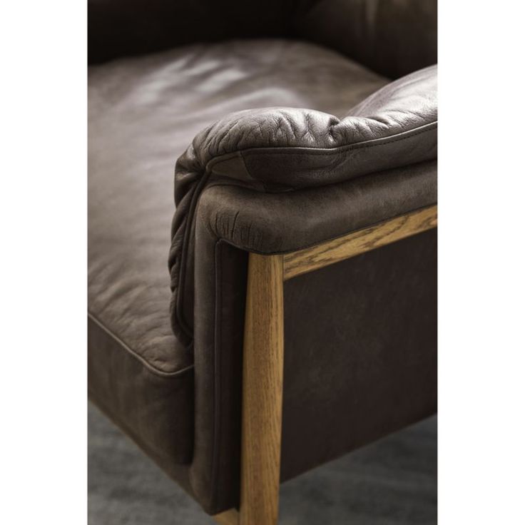 a brown leather chair sitting on top of a carpeted floor next to a wooden frame