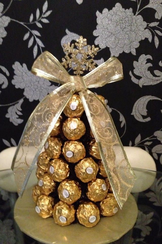 a christmas tree made out of chocolates on top of a gold plated stand